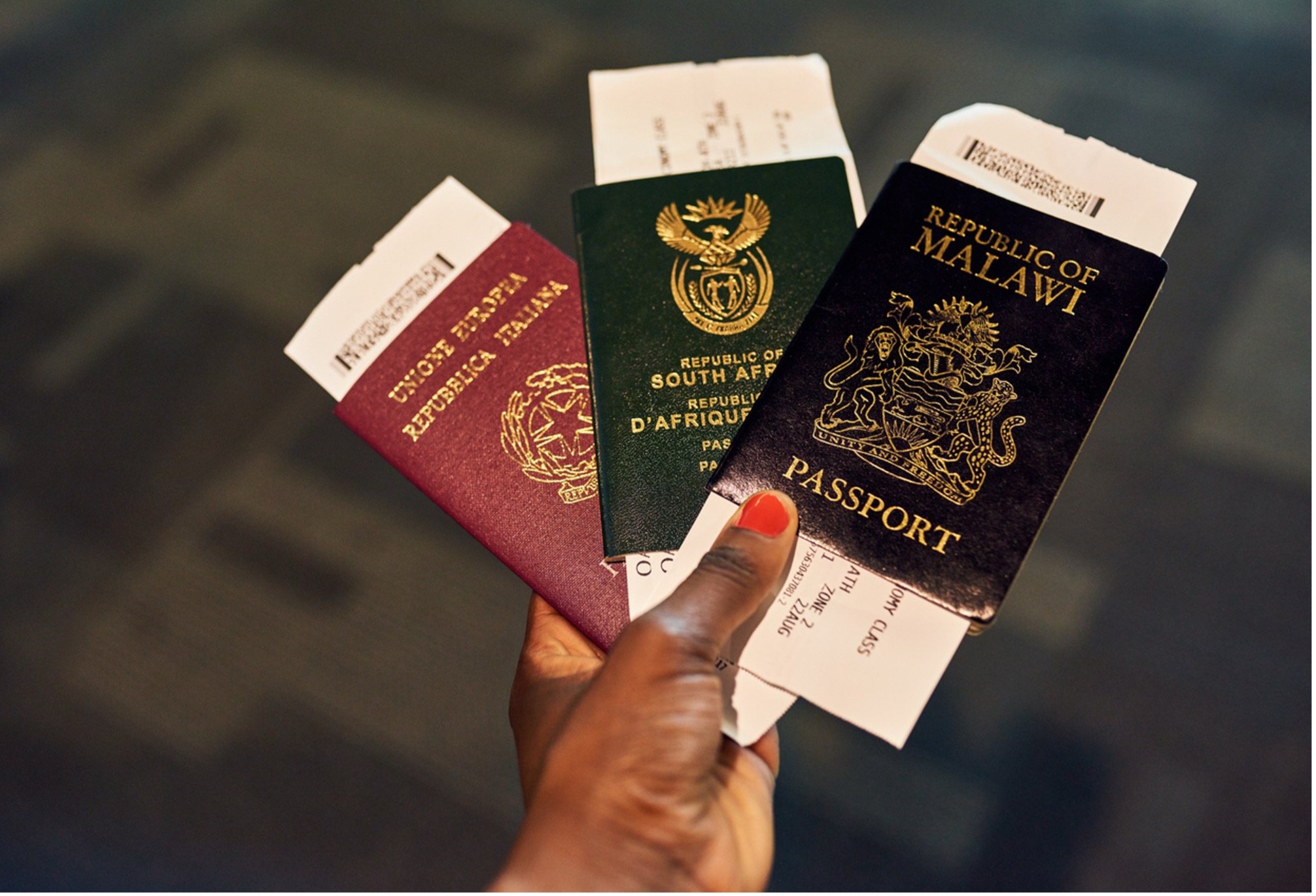 Person holding Italian, South African, and Malawian passports